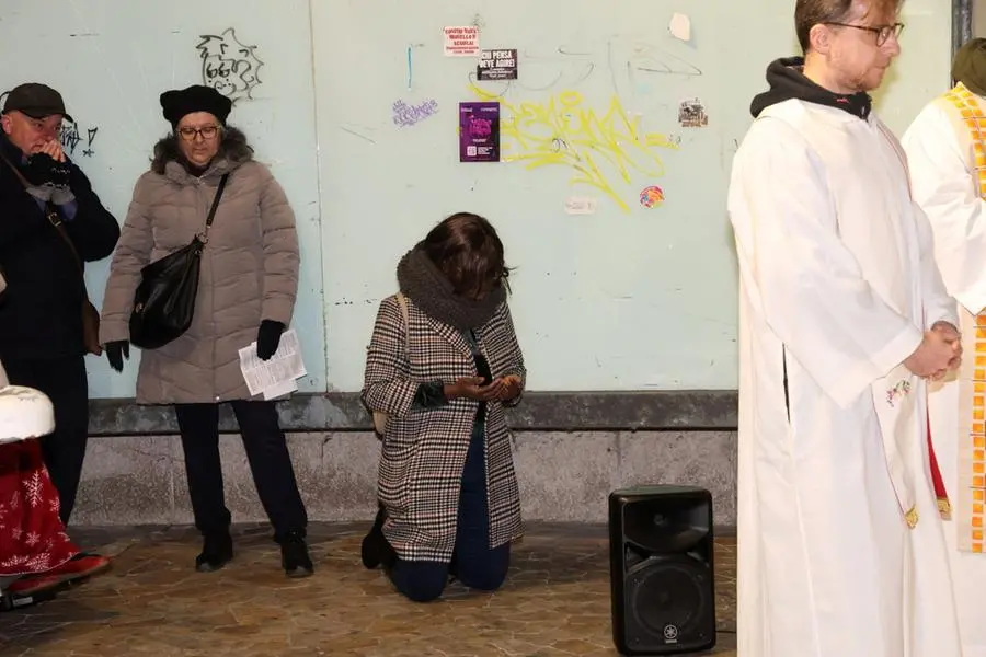 Una donna inginocchiata in preghiera, alla messa della Vigilia celebrata dal vescovo alla stazione Mom