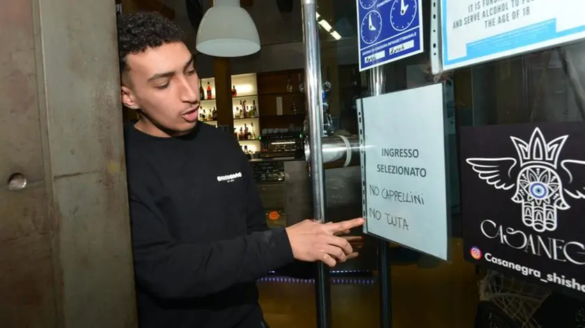 Un barista del locale mostra il cartello anti maranza