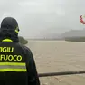Un vigile del fuoco controlla la piena di un fiume