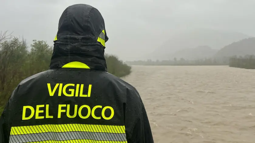 Un vigile del fuoco controlla la piena di un fiume