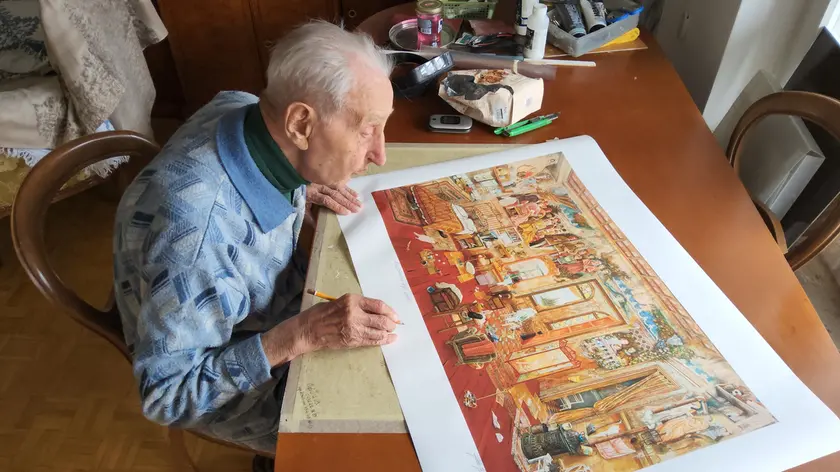 Aldo Bressanutti intento a firmare una delle opere destinate a Shanghai