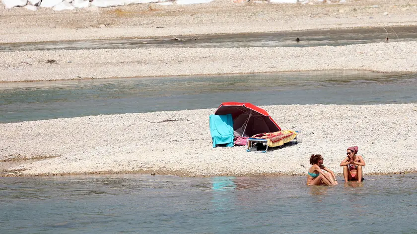 Bagnanti prendono il sole sul greto del Piave