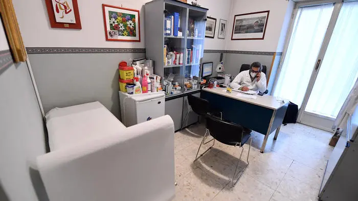 Un medico di base al telefono con un paziente