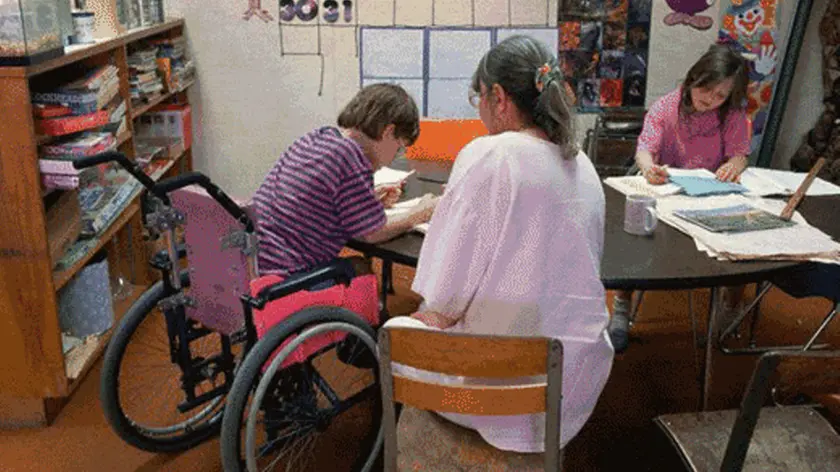Uno studente disabile con l’insegnante di sostegno.