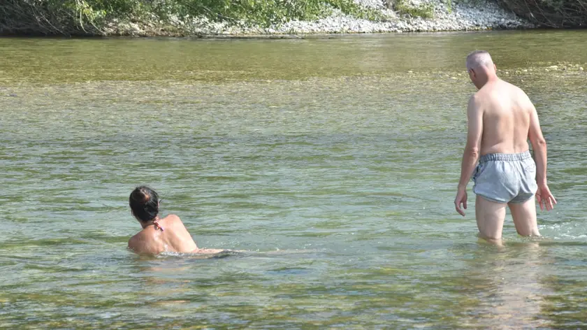 Due persone cercano refrigerio nelle acque del Piave a Vidor (Foto Cavicchi)