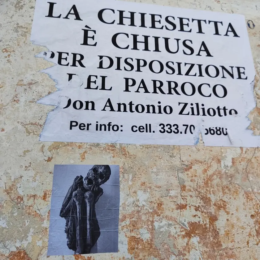 Una foto di uno scheletro affissa sotto uno dei messaggi lasciati dal parroco