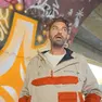 Claudio Daker davanti a un muro pieno di graffiti (Foto Marega). A destra Ultimo con la chitarra decorata dal writer goriziano