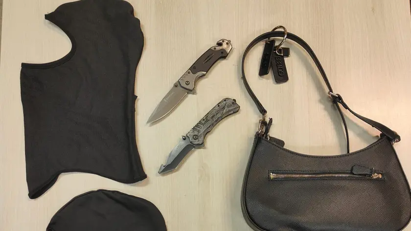 La borsetta di una delle vittime con i coltelli e i passamontagna usati dai rapinatori