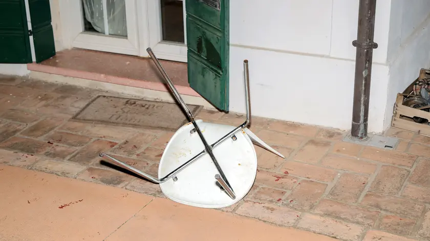 Una sedia a terra e le chiazze di sangue dopo la brutale aggressione a colpi di coltello