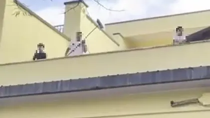 I ragazzini mentre gettano sassi e scope addosso alle forze dell'ordine