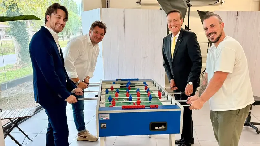 Morosin (in fondo a destra) durante una partita a calcio balilla. Tra gli sfidanti anche il governatore Stefani