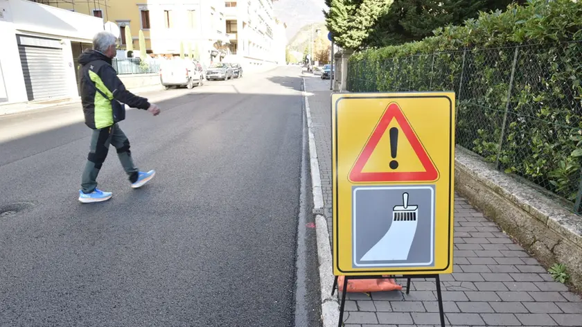 Un passante che attraversa la strada in assenza di strisce pedonali