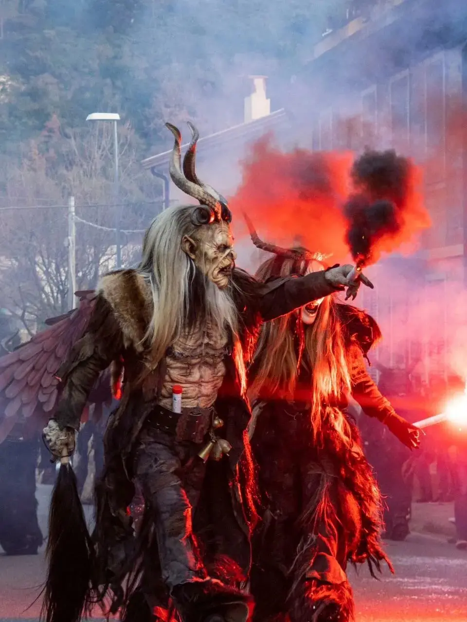 Due Krampus assieme all’angelo nero del gruppo di Merano alle prese con i giochi di fuoco durante una sfilata