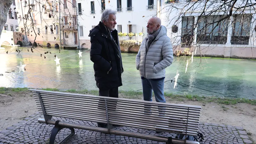 Mario Martinelli mentre conversa con Domenico Basso durante l'intervista sulla panchina sulla riva del Cagnan