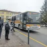 Passeggeri alla fermata di un bus della Mom