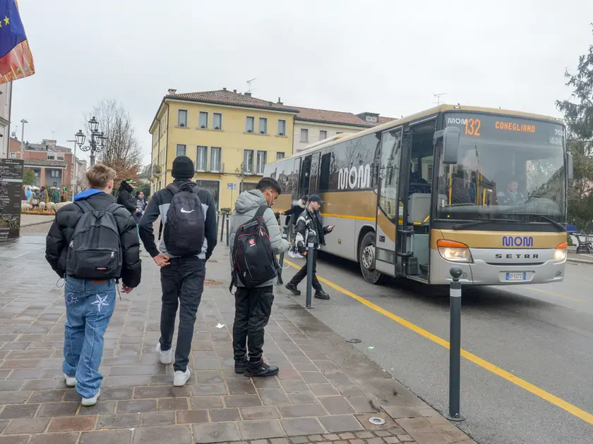 Passeggeri alla fermata di un bus della Mom