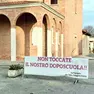 Sopra lo striscione cacciato dalle Fanna e appeso davanti alla chiesa di Selvana.
