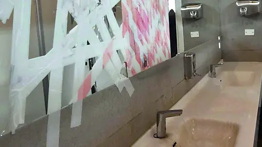 Lo specchio dei bagni maschili in frantumi