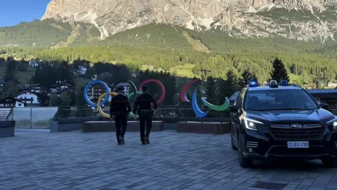 Una pattuglia dell’Arma davanti ai simboli dei Giochi esposti a Cortina