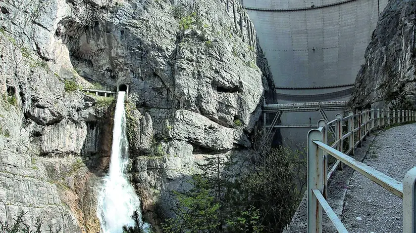 Una veduta della diga del Vajont da valle con la cascata di scarico del by pass e il ponte tubo