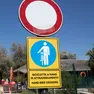 A sinistra la bici “affondata” nella ghiaia, a destra il cartello di “bici a mano” (fotoservizio Katia Bonaventura)