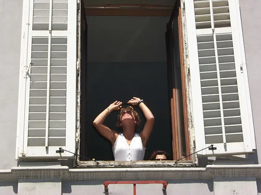 Una donna con gli occhi al cielo per l’eclissi di sole