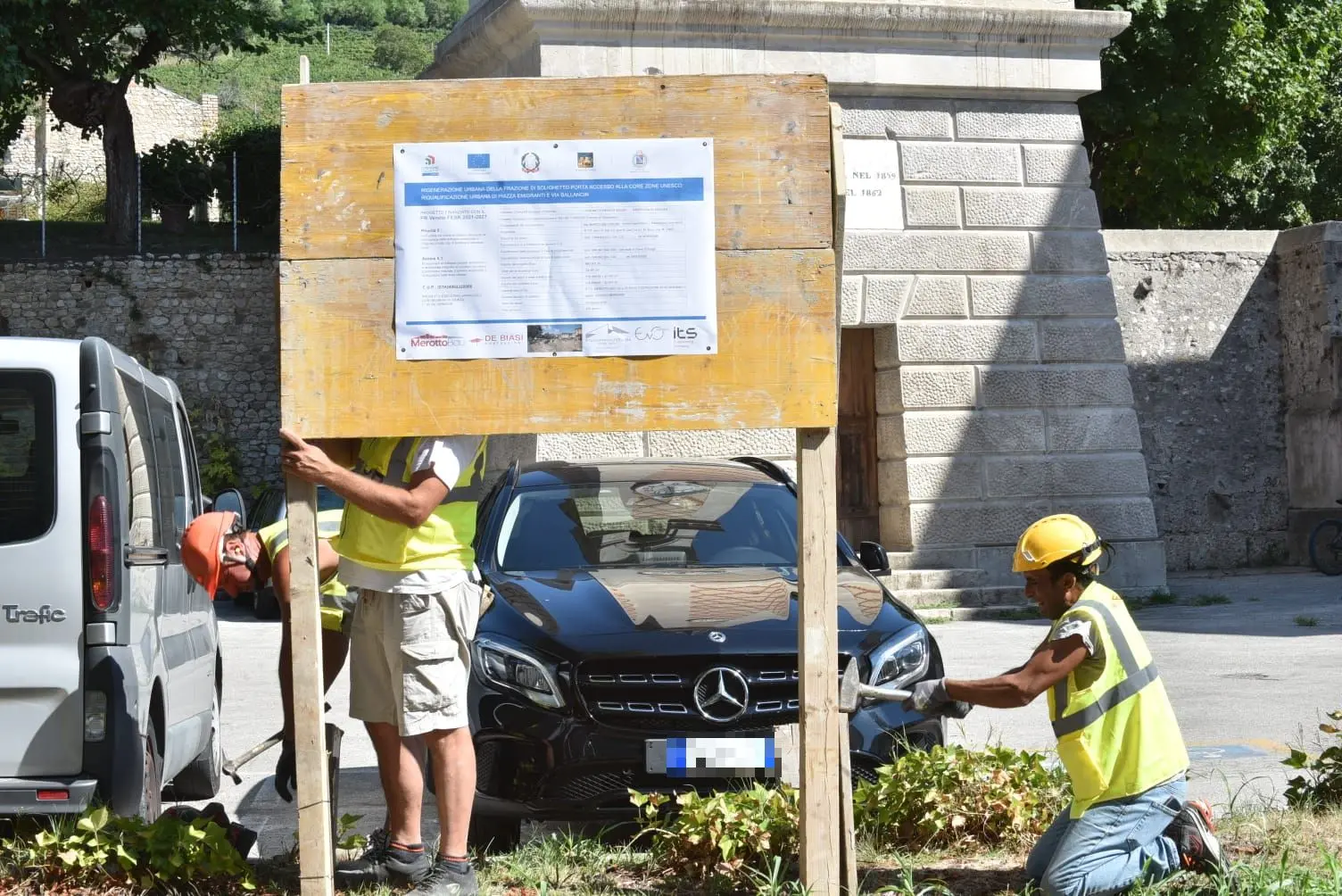 Gli operai affiggono il cartello di cantiere a Solighetto