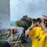 Un gruppo di appassionati con binocoli e teleobiettivi