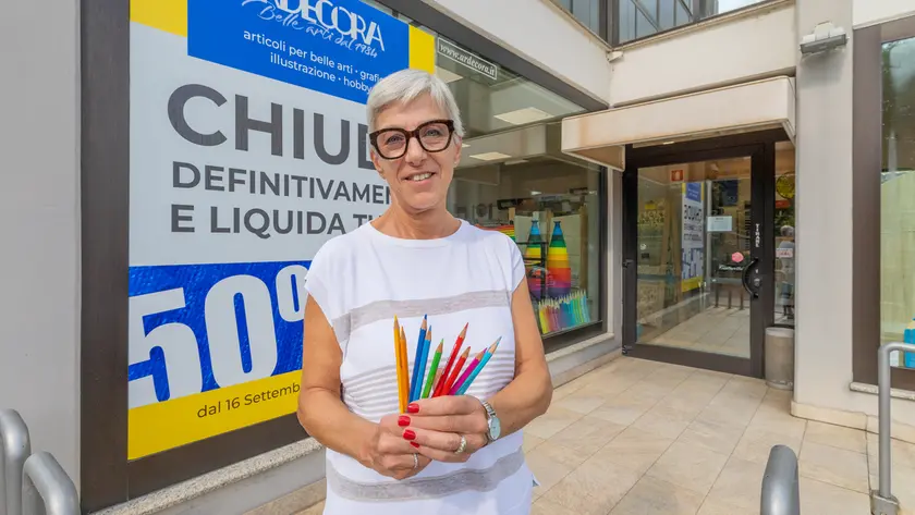 Elviana Varaschin davanti alla vetrina del suo negozio che chiuderà a dicembre