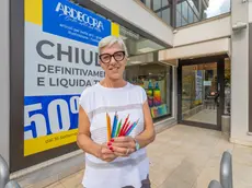 Elviana Varaschin davanti alla vetrina del suo negozio che chiuderà a dicembre