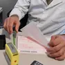 Un medico di base compila una ricetta nel suo studio