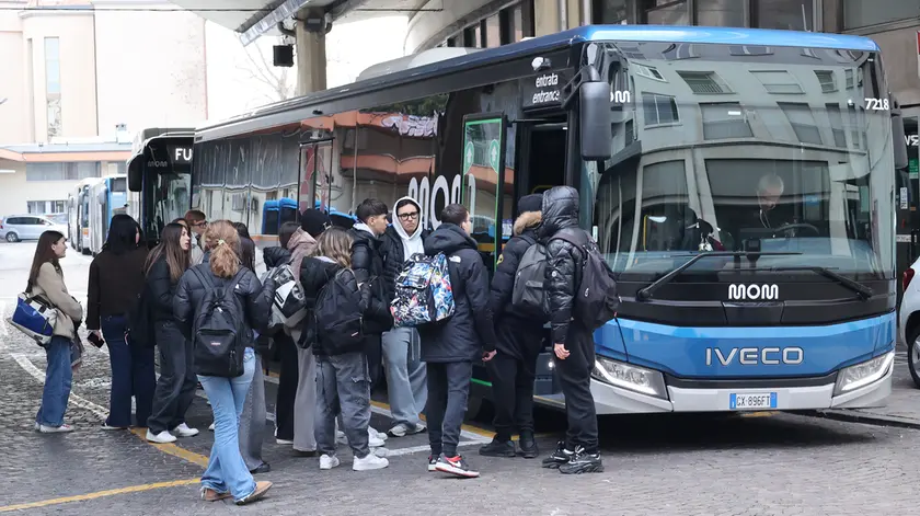 Un gruppo di studenti alla stazione dell'autobus