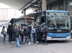 Un gruppo di studenti alla stazione dell'autobus