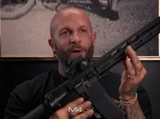Un frame del video in cui Andrea Romanello mostra il fucile d’assalto
