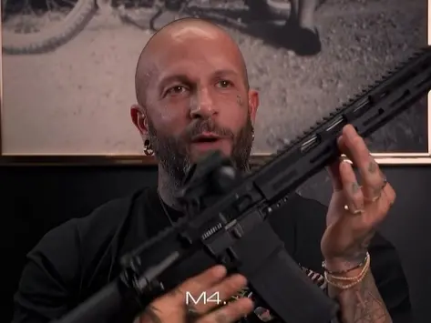 Un frame del video in cui Andrea Romanello mostra il fucile d’assalto