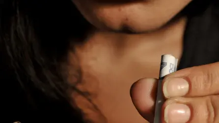Un donna si appresta a sniffare polvere bianca come cocaina in una ricostruzione fotografata del 29 luglio 2009. ANSA/ GUIDO MONTANI