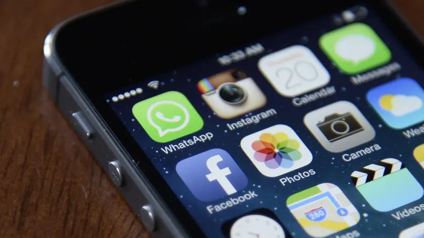 epa04091106 The Facebook and WhatsApp app icons are displayed on an iPhone in New York, New York 20 February 2014. Facebook announced that it acquired the globally popular messaging system WhatsApp for 19 billion dollars. Facebook paid 12 billion dollars in shares and 4 billion dollars in cash, it was explained in a conference call. The deal includes an additional 3 billion dollars in Facebook stock for WhatsApp founders and employees. The deal should close later in 2014 and is still subject to regulatory approval, according to Facebook founder and Chief Executive Officer Mark Zuckerberg, who said in the conference call that he did not expect any issues. Additionally, WhatsApp co-founder and Chief Executive Officer Jan Koum will join the Facebook Board of Directors. EPA/ANDREW GOMBERT