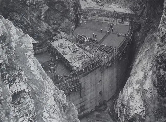 Una fase della costruzione della diga del Vajont. Sotto, i soccorsi dopo il disastro in una foto di Giorgio Salomon (riproduzione riservata)