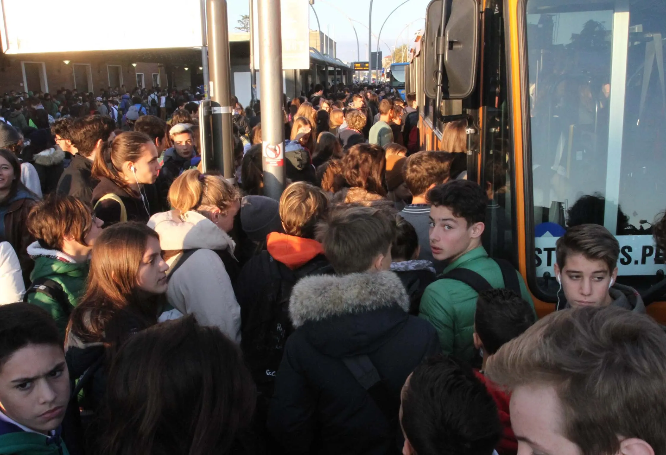 Folla di studenti al mattino alla stazione dei treni per l'attesa dei bus