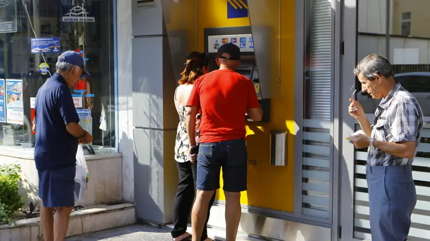 A small queue has formed at the ATMs at this Piraeus Bank branch in Rhodes, as people try to withdraw money. Banks in Greece will be closed and the withdrawal of money restricted to 60 Euros per day for a week ahead of the referendum in Greece about the acceptance of the reforms demanded by the creditors. However some ATM seems already to be empty. (Photo by Michael Debets / Pacific Press) Lapresse Only italy.Banche chiuse in Grecia per una settimana