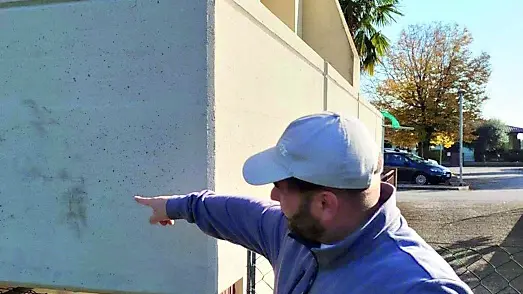 Giovanni Accentura mostra l’impronta degli scarponi sul muro
