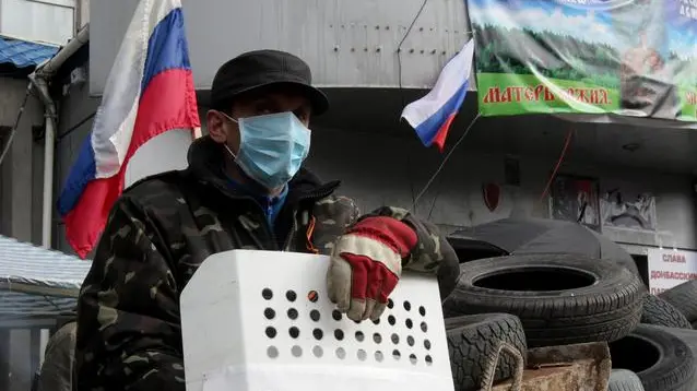 epa04166874 A pro-Russian activist guards the entrance of the security service building occupied by Pro-Russian activists in Lugansk, Ukraine, 14 April 2014. The pro-Russian activists occupying state institutions in eastern Ukraine said 14 April that they will not heed an ultimatum by the government in Kiev. Ukraine's acting President Oleksandr Turchynov on 13 April warned that a military operation would be launched against them if the separatists did not lay down their arms by 0700 GMT. The situation escalated over the weekend when armed men in camouflage uniforms seized numerous police stations and administrative buildings in Ukraine's eastern Russian-speaking provinces. EPA/ZURAB KURTSIKIDZE