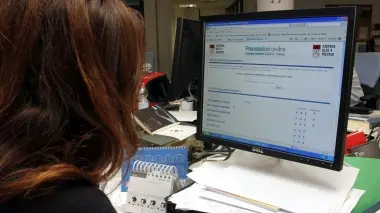Sullo schermo del computer il sito dell’Usl 9 di Treviso alla pagina per le prenotazioni delle visite online. In alto, il poliambulatorio a Borgo Cavalli: il nuovo servizio web consentirà di evitare le code