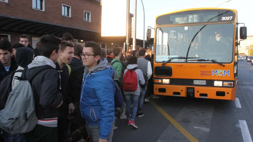 Folla di studenti al mattino alla stazione dei treni per l'attesa dei bus