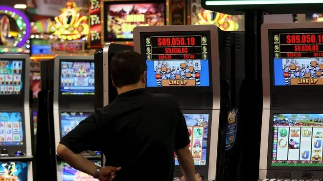 Un uomo gioca con una slot machine in una foto d'archivio. ANSA / YM YIK .