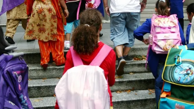 Alcuni bambini entrano in classe a Milano in una foto d'archivio. ANSA / VINCE GERACE