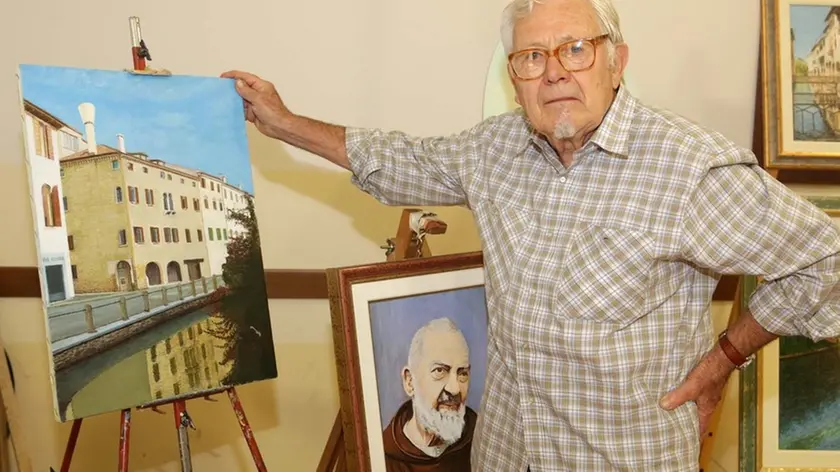Luigi Danesin, 83 anni, con il quadro che stava dipingendo in via Roggia