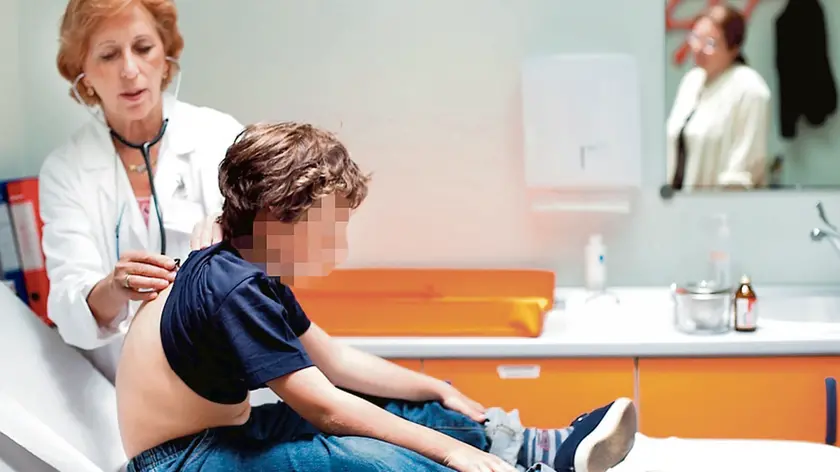 Un ragazzino visitato da una pediatra