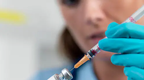 Doctor filling a syringe