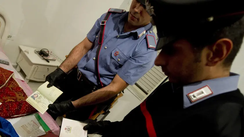 Un momento del blitz dei carabinieri del Comando provinciale di Napoli che ha portato all'arresto di otto extracomunitari appartenenti all'organizzazione mafiosa nigeriana ''Black Axe '' (ascia nera), con l'accusa di associazione per delinquere di tipo mafioso e, a vario titolo, di estorsioni, sfruttamento della prostituzione, porto e detenzione illegale di armi, minacce e lesioni personali, contraffazione di documenti di identita', Napoli, 30 settembre 2011. ANSA/CIRO FUSCO